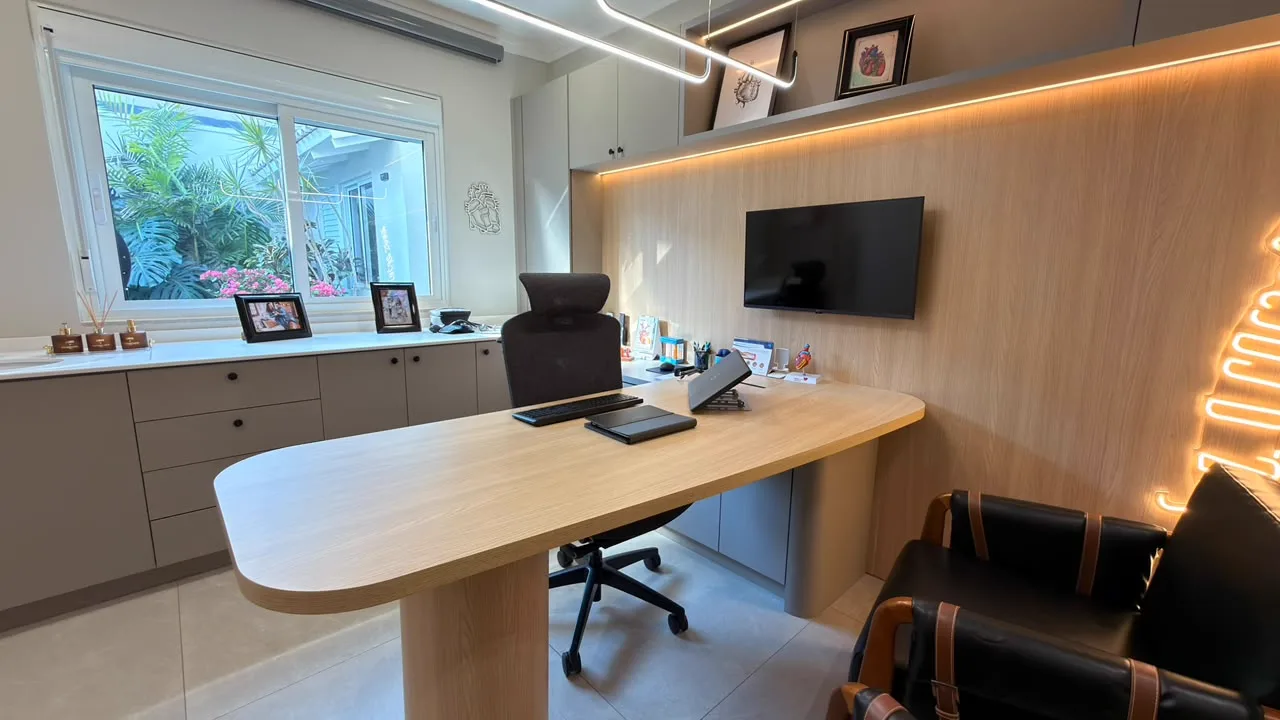 Consultório com mesa de madeira e painel iluminado