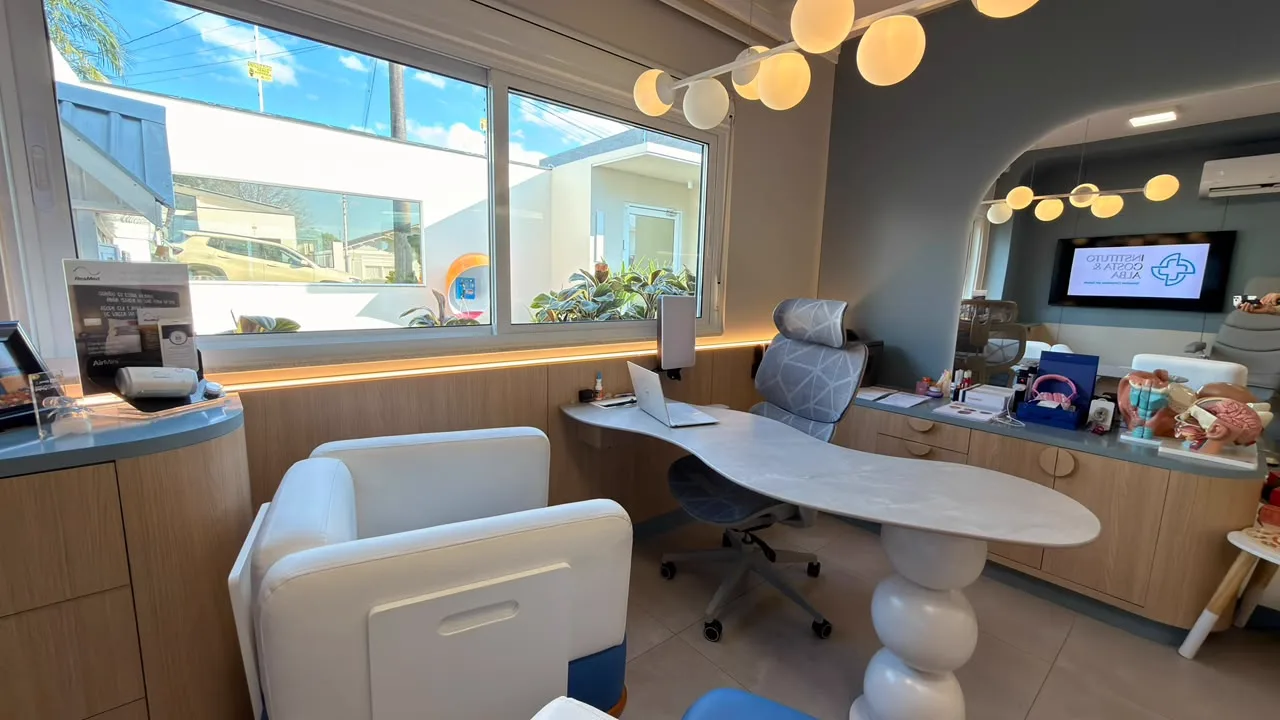 Consultório com mesa de atendimento e janela para o jardim